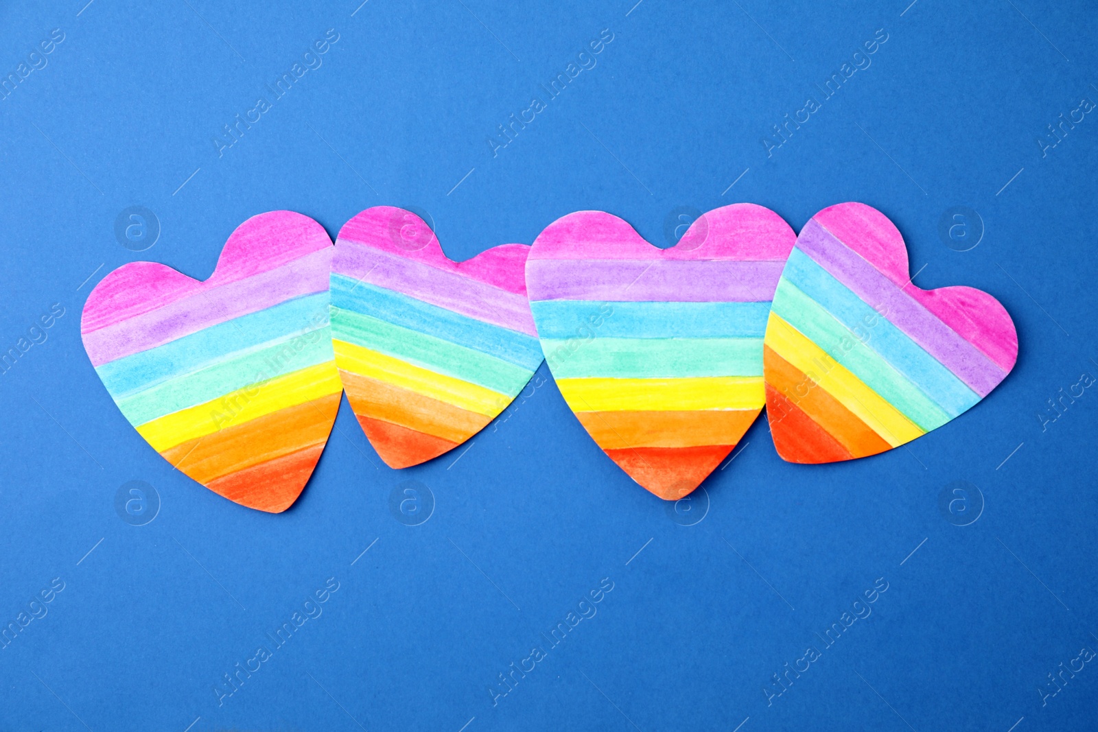 Photo of Rainbow hearts on color background, top view. Gay symbol