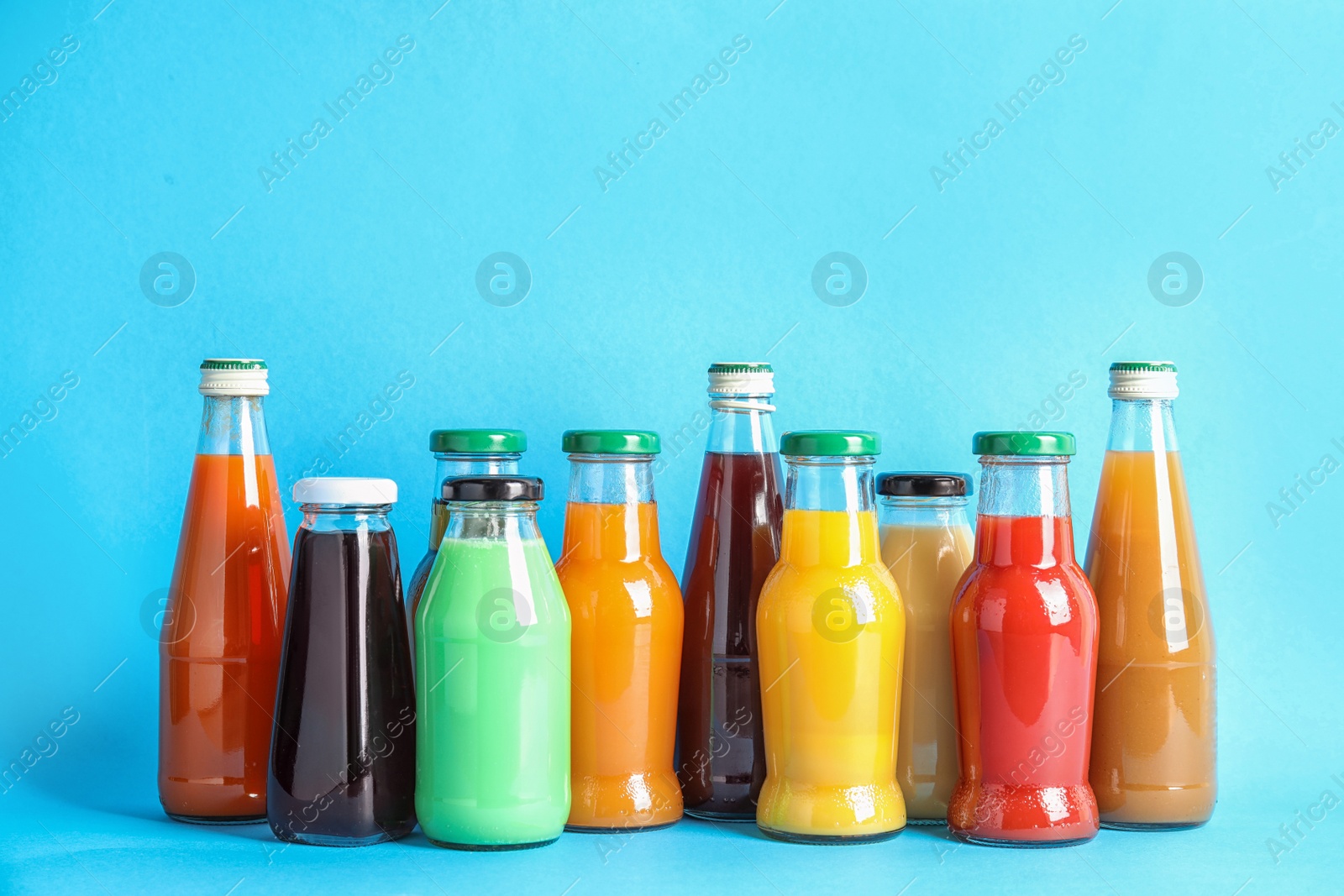 Photo of Bottles with different juices on color background