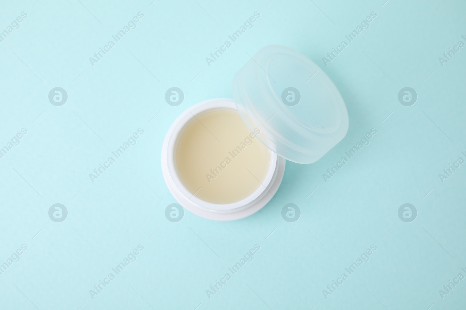 Photo of Jar of petroleum jelly on light blue background, top view