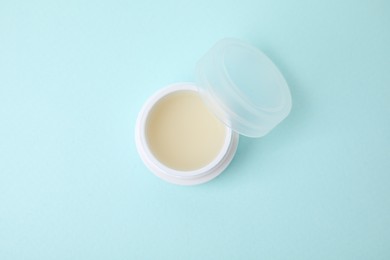 Jar of petroleum jelly on light blue background, top view