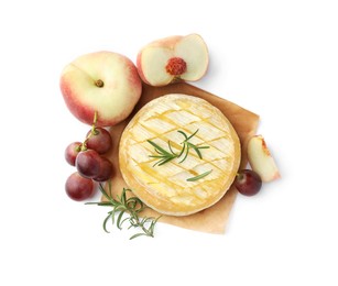 Photo of Tasty baked brie cheese with rosemary, grapes and peaches isolated on white, top view
