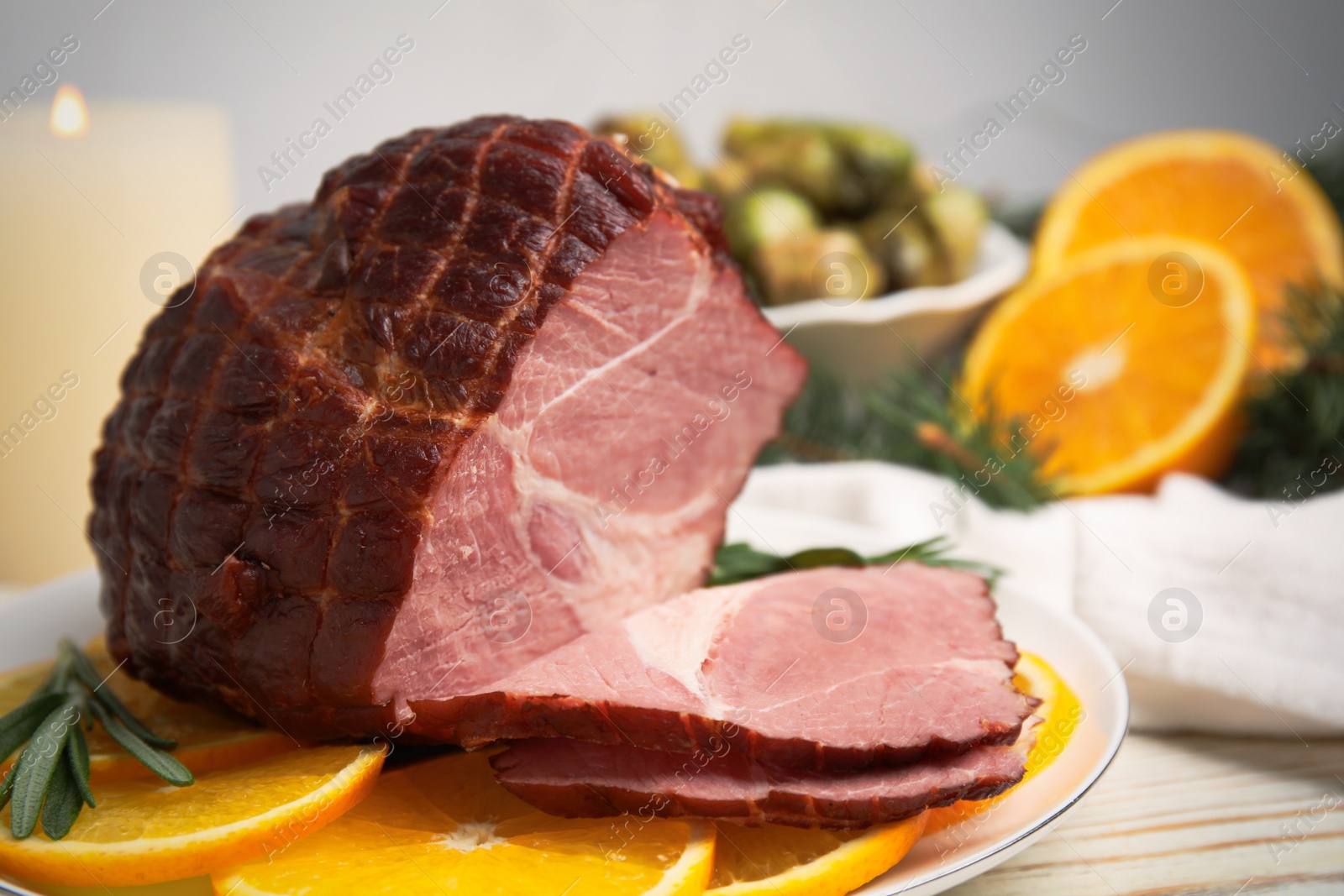 Photo of Delicious ham served with orange and rosemary on white wooden table, closeup