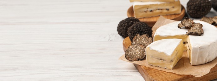 Image of Soft cheese and fresh truffles on white wooden table, space for text. Banner design