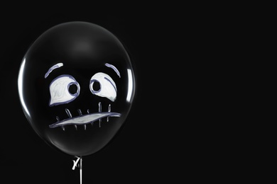 Spooky balloon for Halloween party on black background, space for text