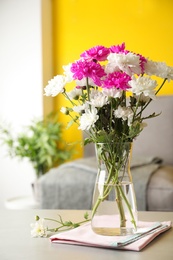 Photo of Beautiful bouquet of Chrysanthemum flowers on grey table indoors. Interior design