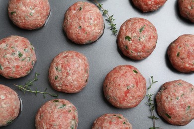 Photo of Many fresh raw meatballs on baking dish, flat lay