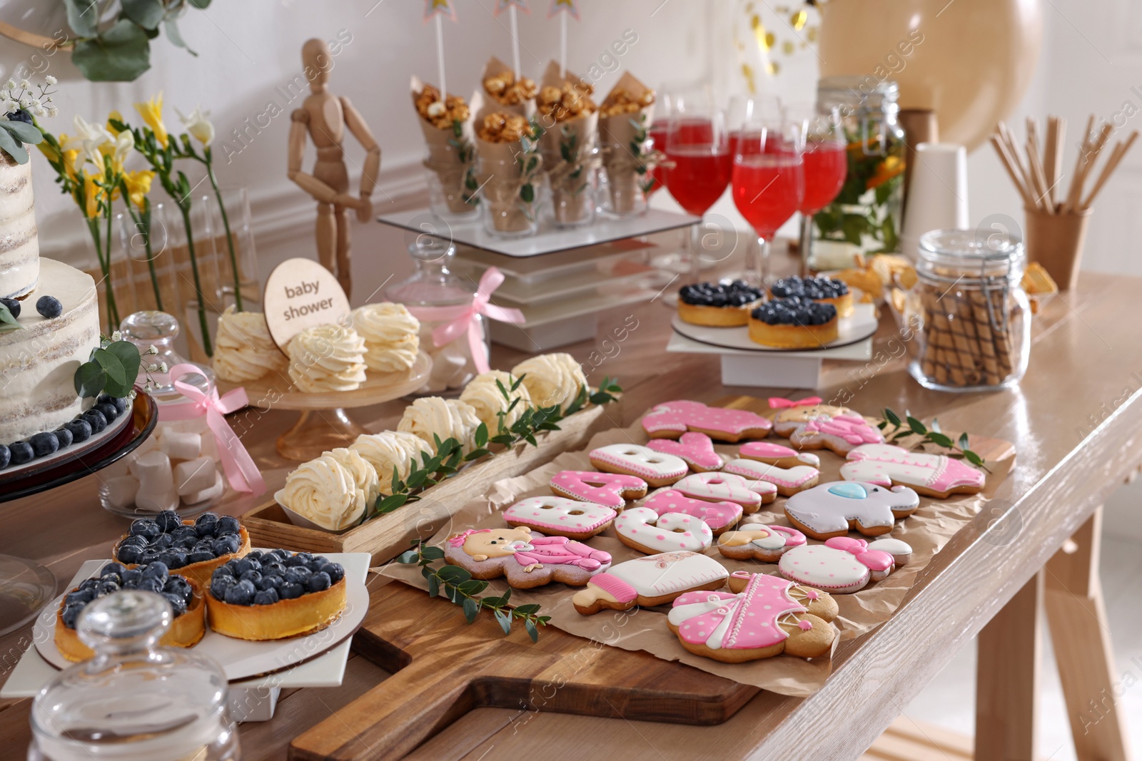 Photo of Baby shower party. Different delicious treats on wooden table indoors