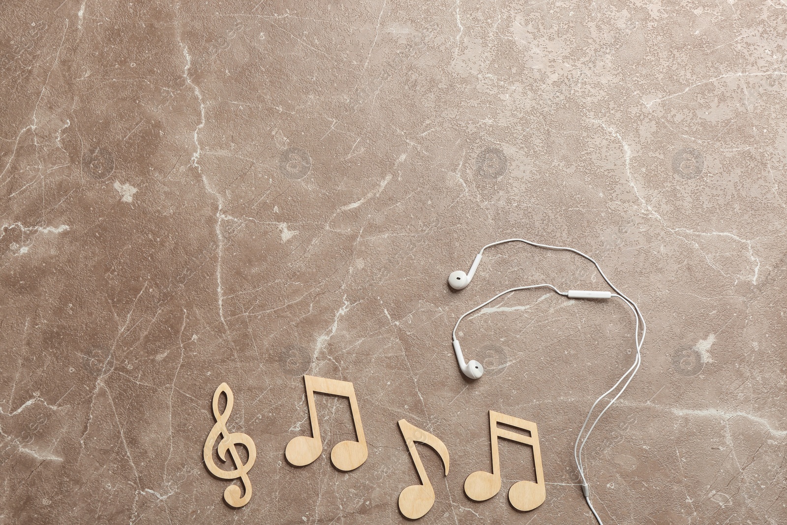 Photo of Flat lay composition with music notes, earphones and space for text on color background