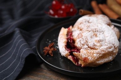 Delicious buns with berries, sugar powder and anise on table, closeup