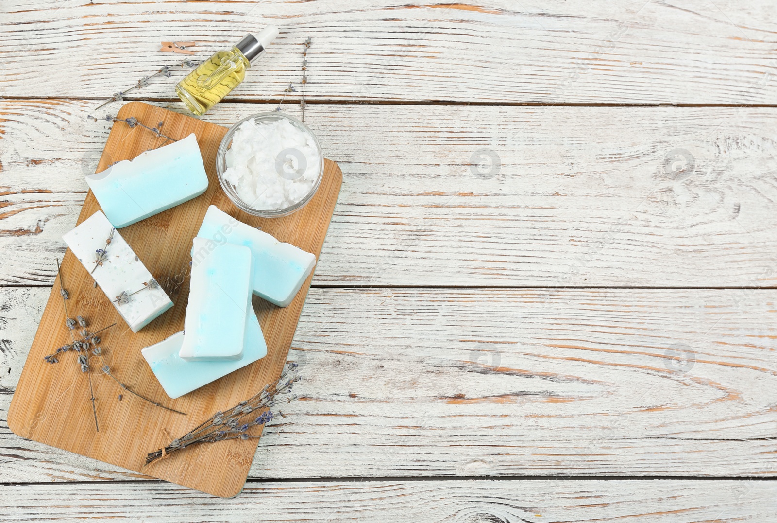 Photo of Flat lay composition with natural handmade soap and ingredients on white wooden table, space for text