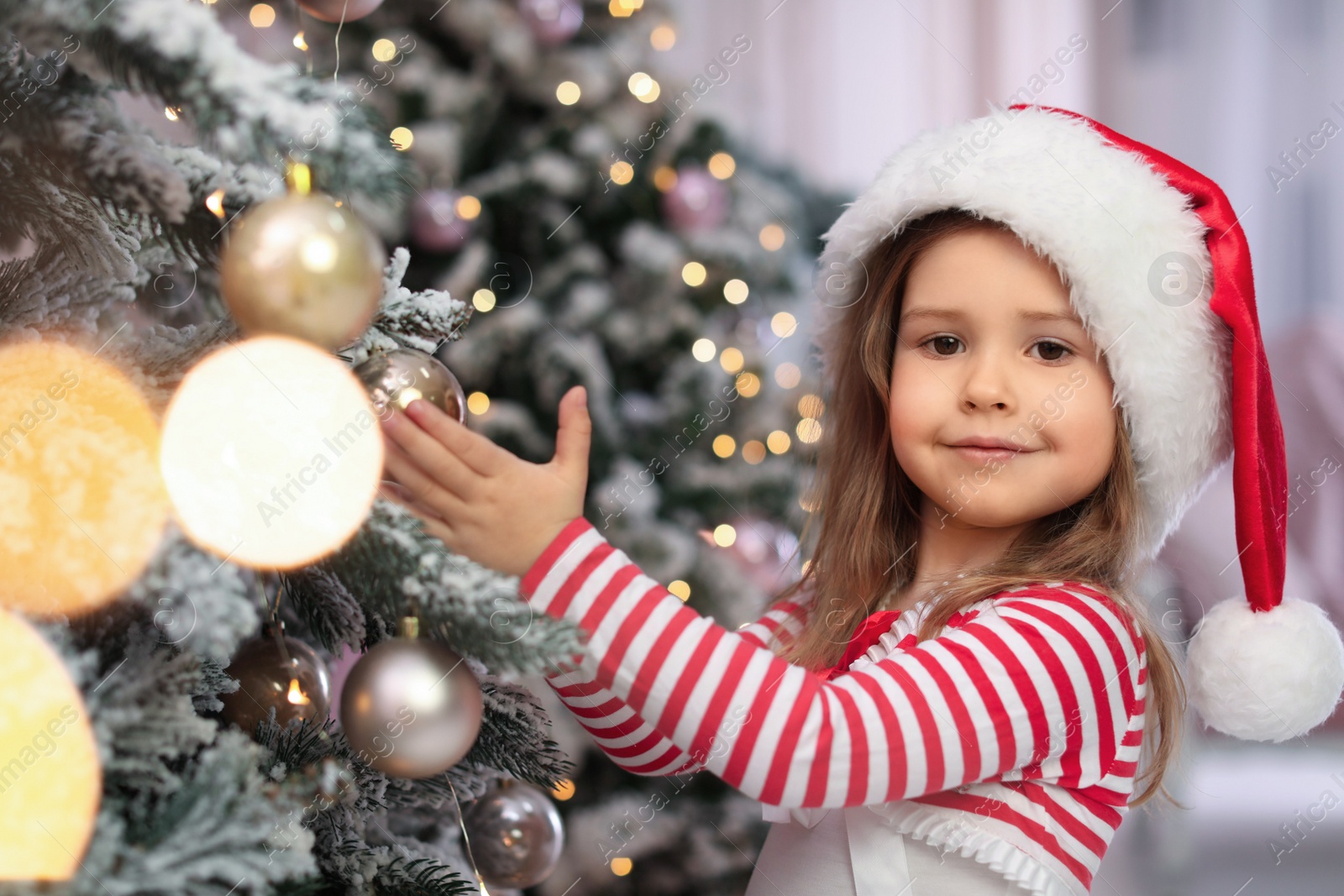 Photo of Cute little child near Christmas tree at home