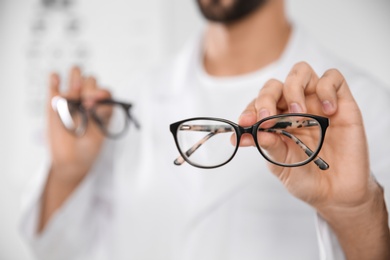 Photo of Male ophthalmologist with eyeglasses in clinic, closeup. Space for text