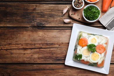 Photo of Delicious fish aspic served on wooden table, flat lay. Space for text