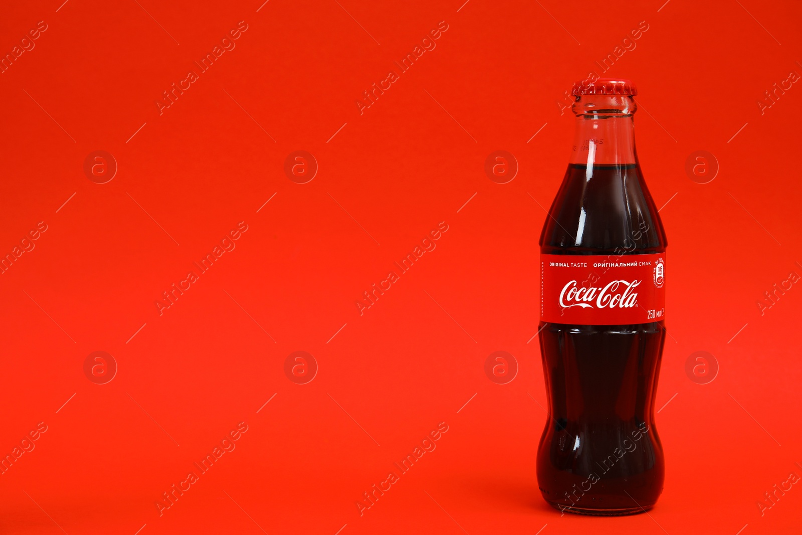 Photo of MYKOLAIV, UKRAINE - NOVEMBER 14, 2018: Bottle of Coca-Cola on color background. Space for text