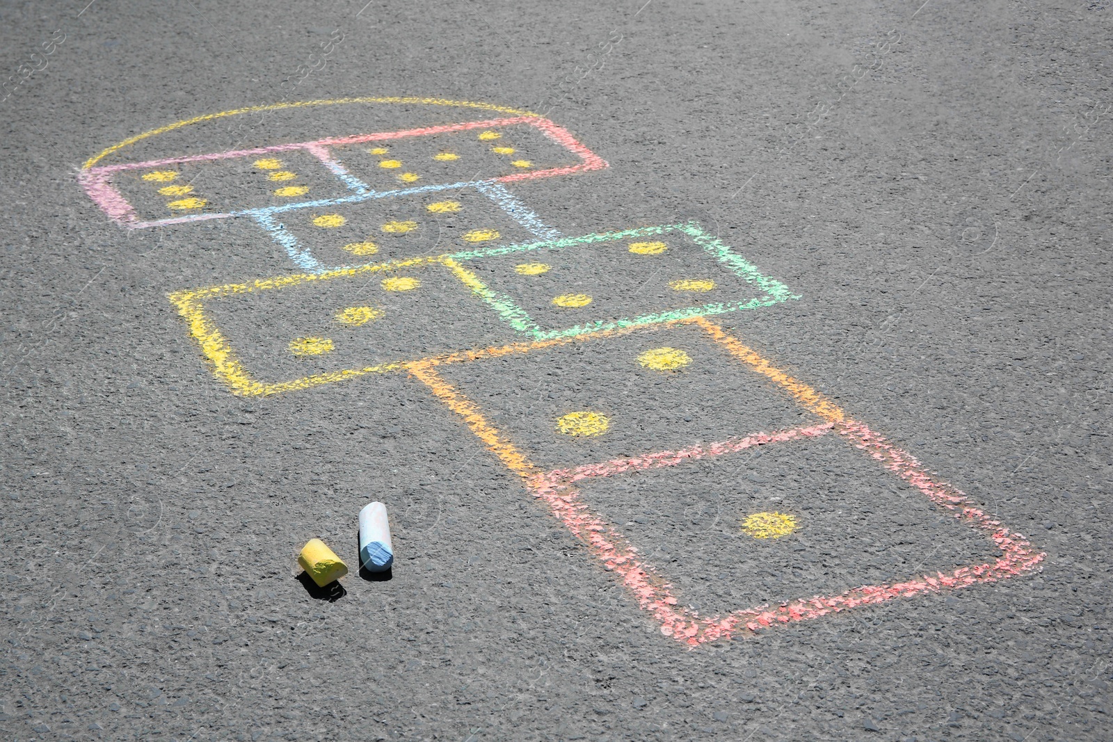 Photo of Hopscotch drawn with colorful chalk on asphalt outdoors