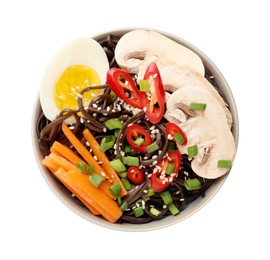 Photo of Tasty buckwheat noodles (soba) with chili pepper, egg, carrot and mushrooms in bowl isolated on white, top view