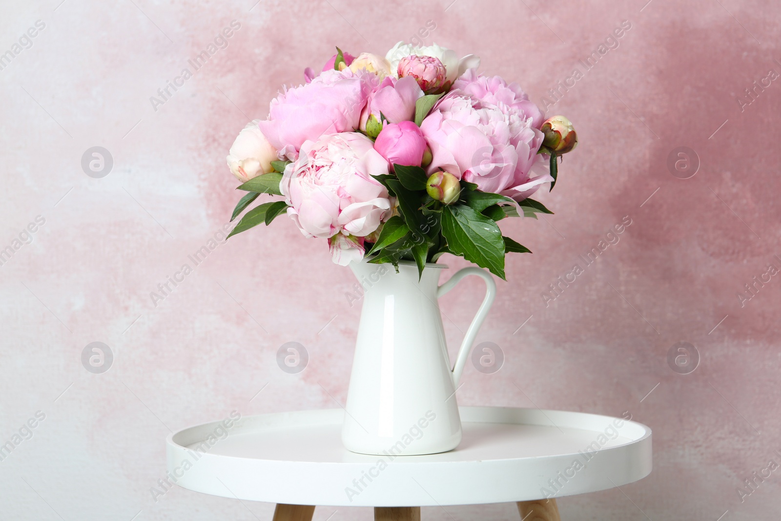 Photo of Bouquet of beautiful peonies in vase on white table