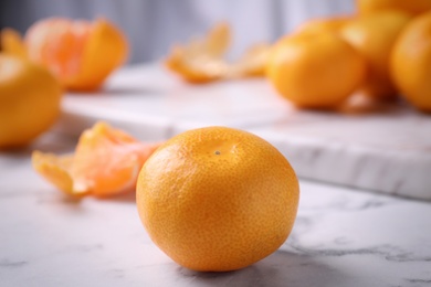 Photo of Delicious fresh tangerine on white marble table
