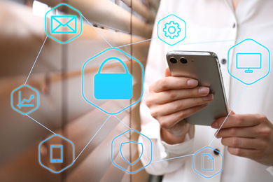 Information security. Young woman using smartphone indoors, closeup