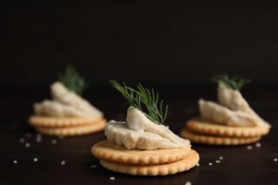 Photo of Delicious crackers with humus and dill on wooden table