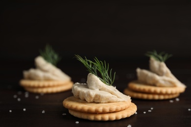 Delicious crackers with humus and dill on wooden table