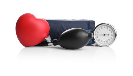 Blood pressure meter and toy heart on white background