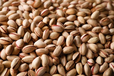 Photo of Many tasty pistachios as background, closeup view
