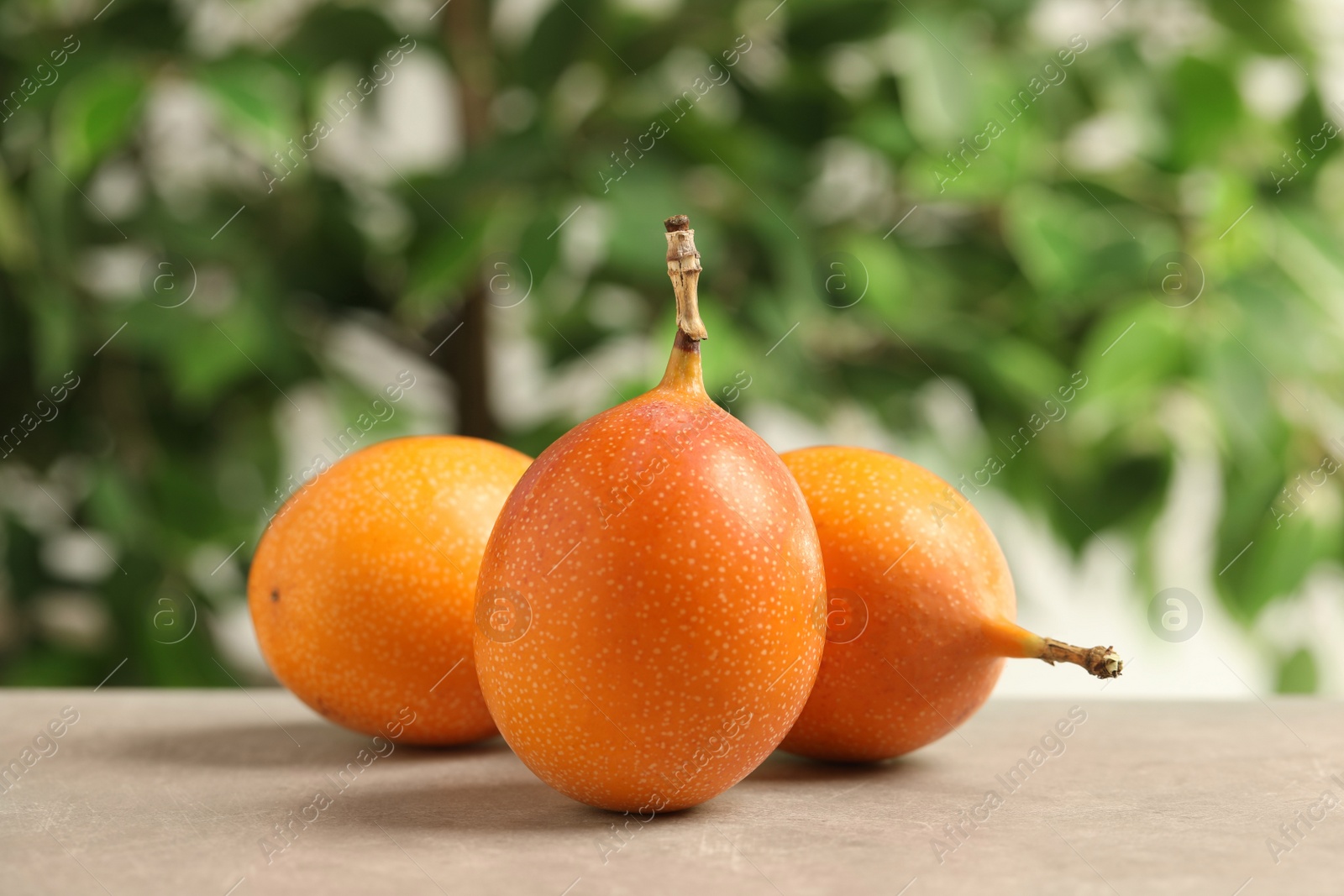 Photo of Whole delicious ripe granadillas on light grey table