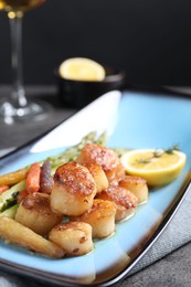 Delicious fried scallops with asparagus served on grey table