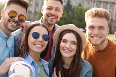 Photo of Happy people taking selfie outdoors on sunny day