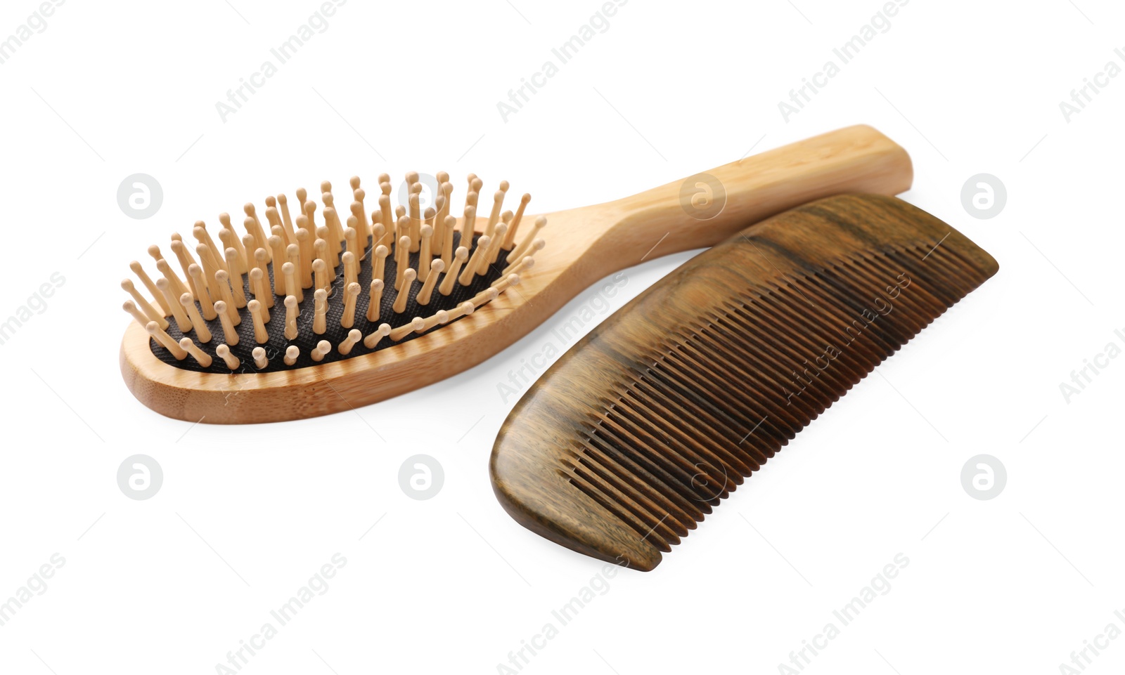 Photo of New wooden hair brush and comb on isolated white