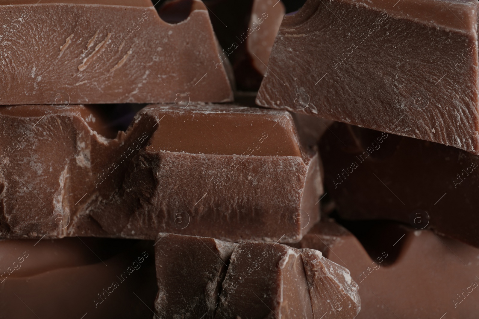 Photo of Pieces of milk chocolate as background, closeup