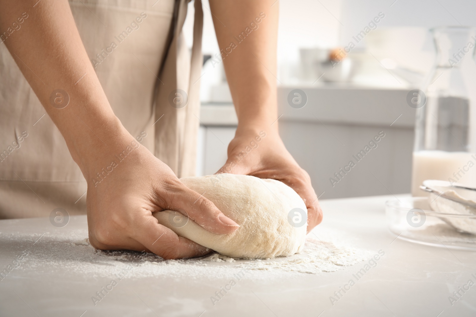 Photo of Woman kneading dough for pastry on table