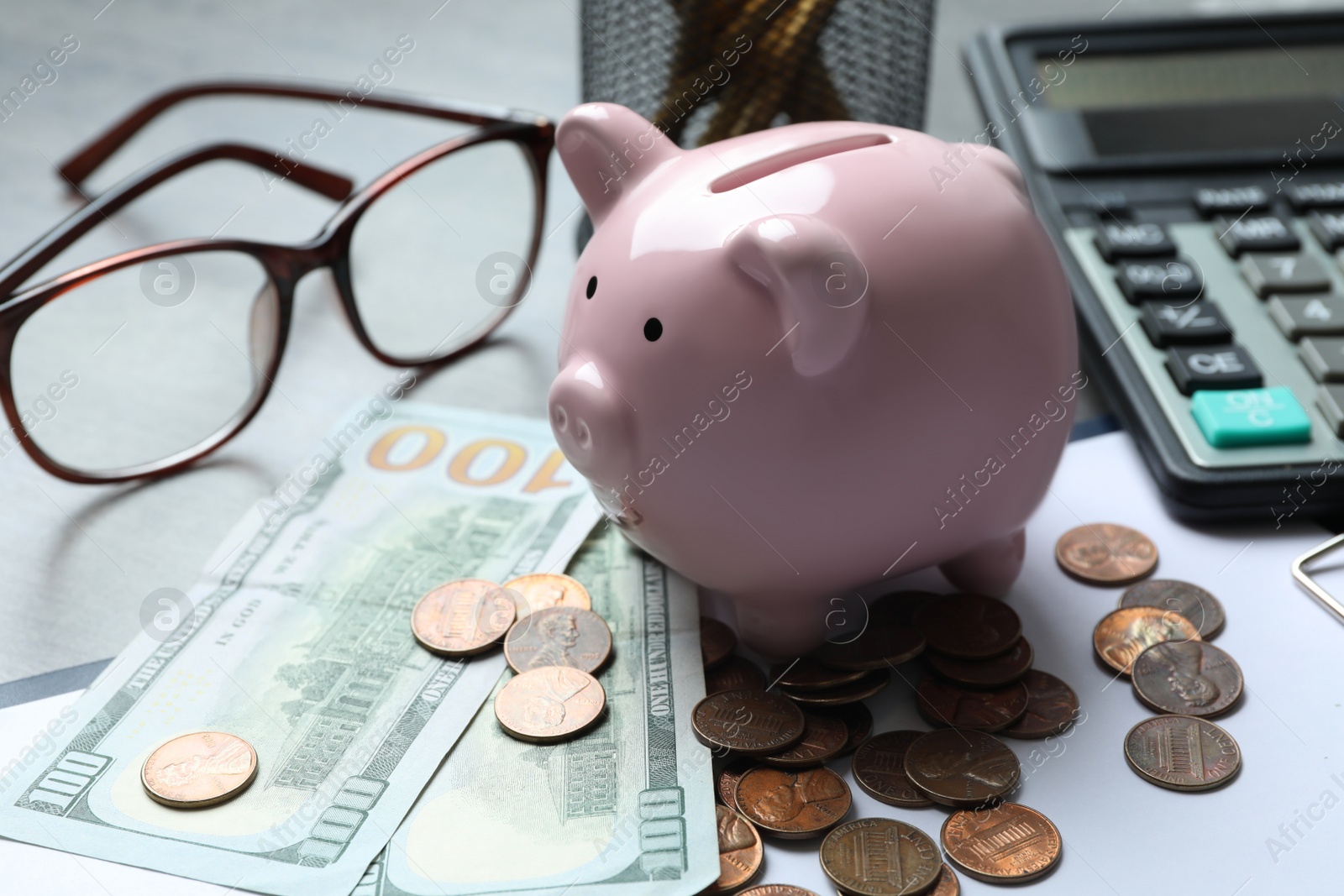 Photo of Pink piggy bank and money on light grey table