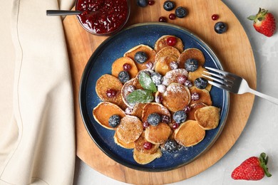 Photo of Cereal pancakes with berries on light grey marble table, flat lay