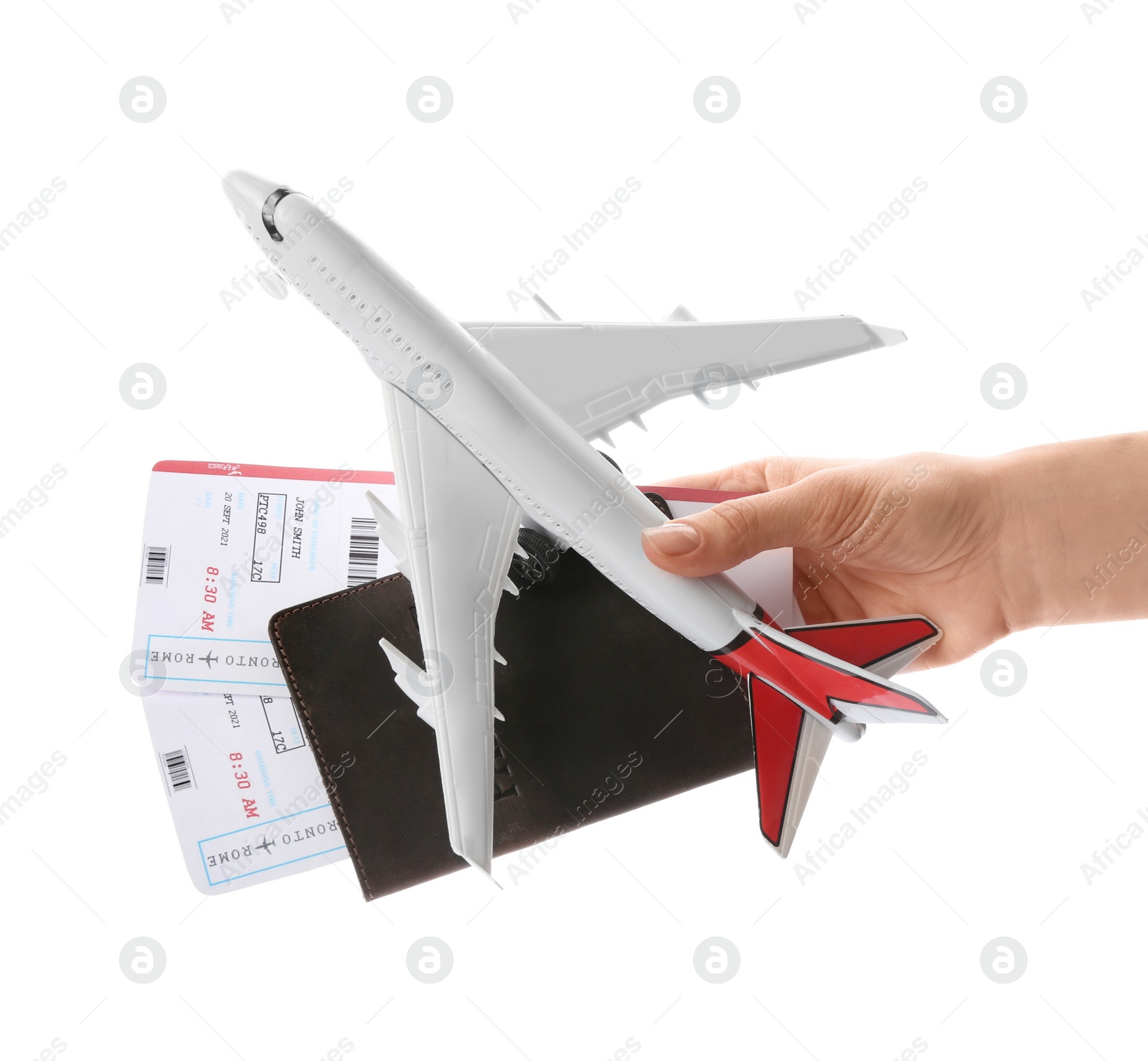 Photo of Woman holding toy airplane, passport and tickets on white background, closeup