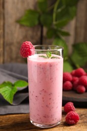 Glass of tasty fresh raspberry smoothie on wooden table