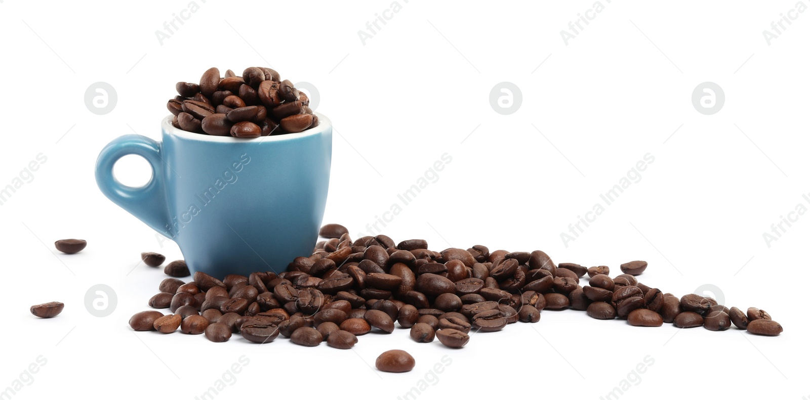 Photo of Coffee beans and overturned light blue cup isolated on white