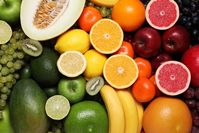Photo of Many different fresh fruits and grapes as background, top view