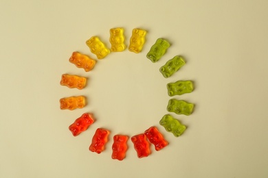 Photo of Flat lay composition with delicious jelly bears on color background. Space for text