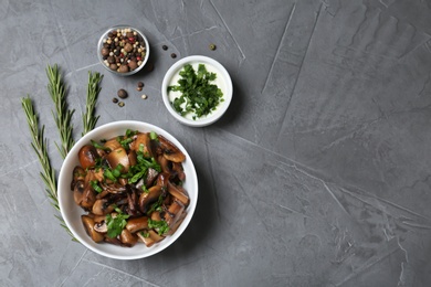 Photo of Flat lay composition with bowl of fried mushrooms and space for text on grey background