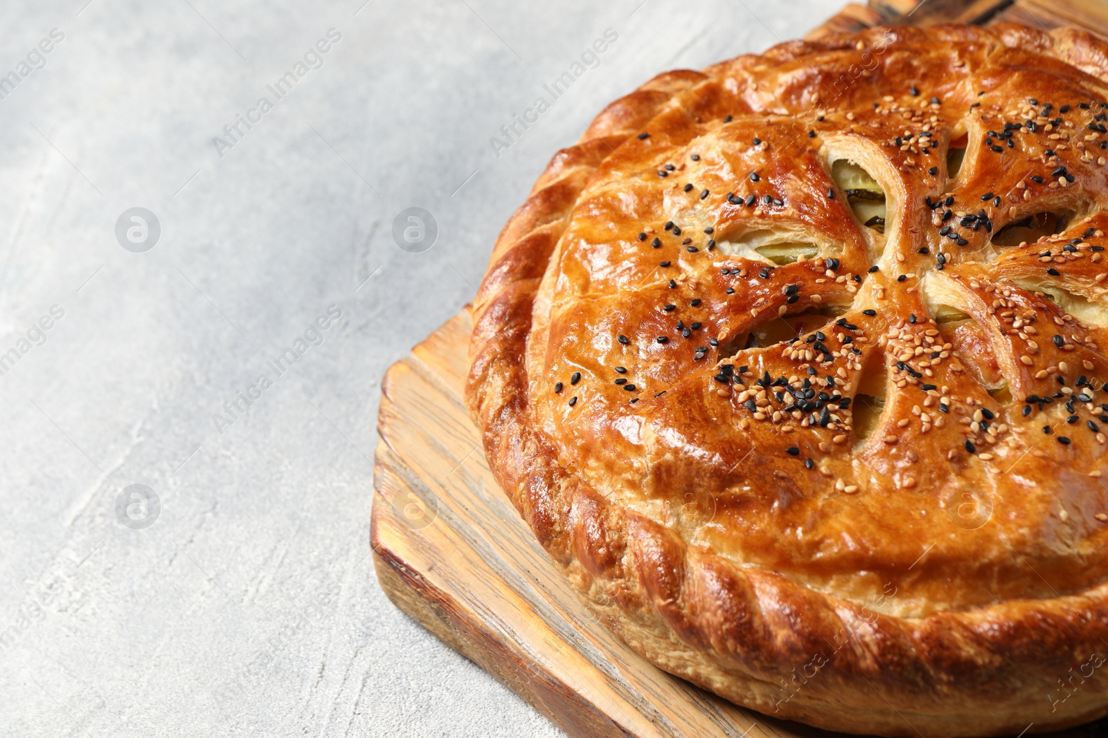 Photo of Tasty homemade pie with filling on light grey table, closeup. Space for text