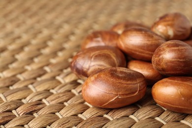 Photo of Many raw jackfruit seeds on wicker mat, closeup. Space for text