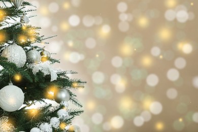 Image of Beautiful Christmas tree with bright baubles against blurred lights on golden background, closeup. Space for text