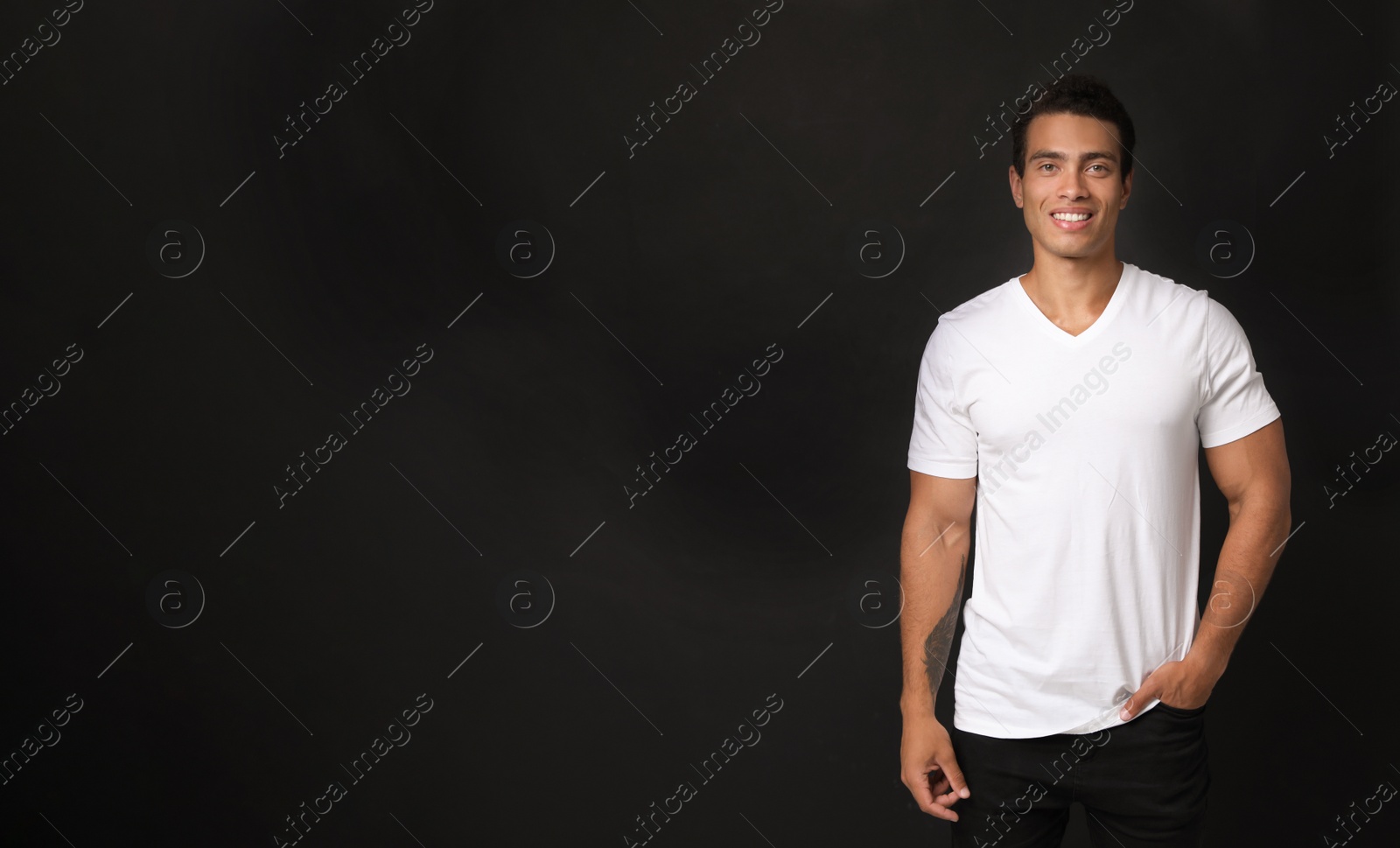 Photo of Handsome young African-American man on black background