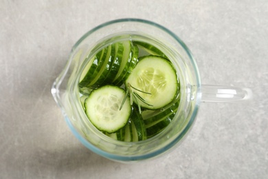 Photo of Jug of fresh cucumber water on grey table, top view