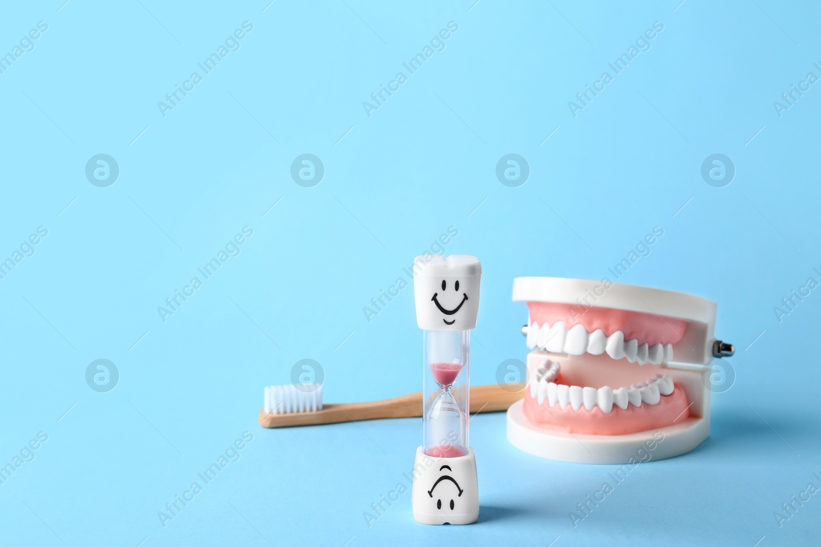 Photo of Composition with dental hourglass on color background, space for text. Healthy teeth