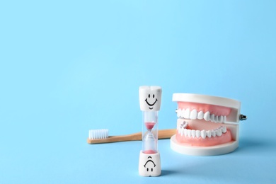 Composition with dental hourglass on color background, space for text. Healthy teeth