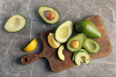 Photo of Flat lay composition with ripe avocados and lemon on grey background