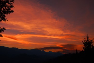 Image of Picturesque view of mountain landscape and beautiful orange sky at sunset